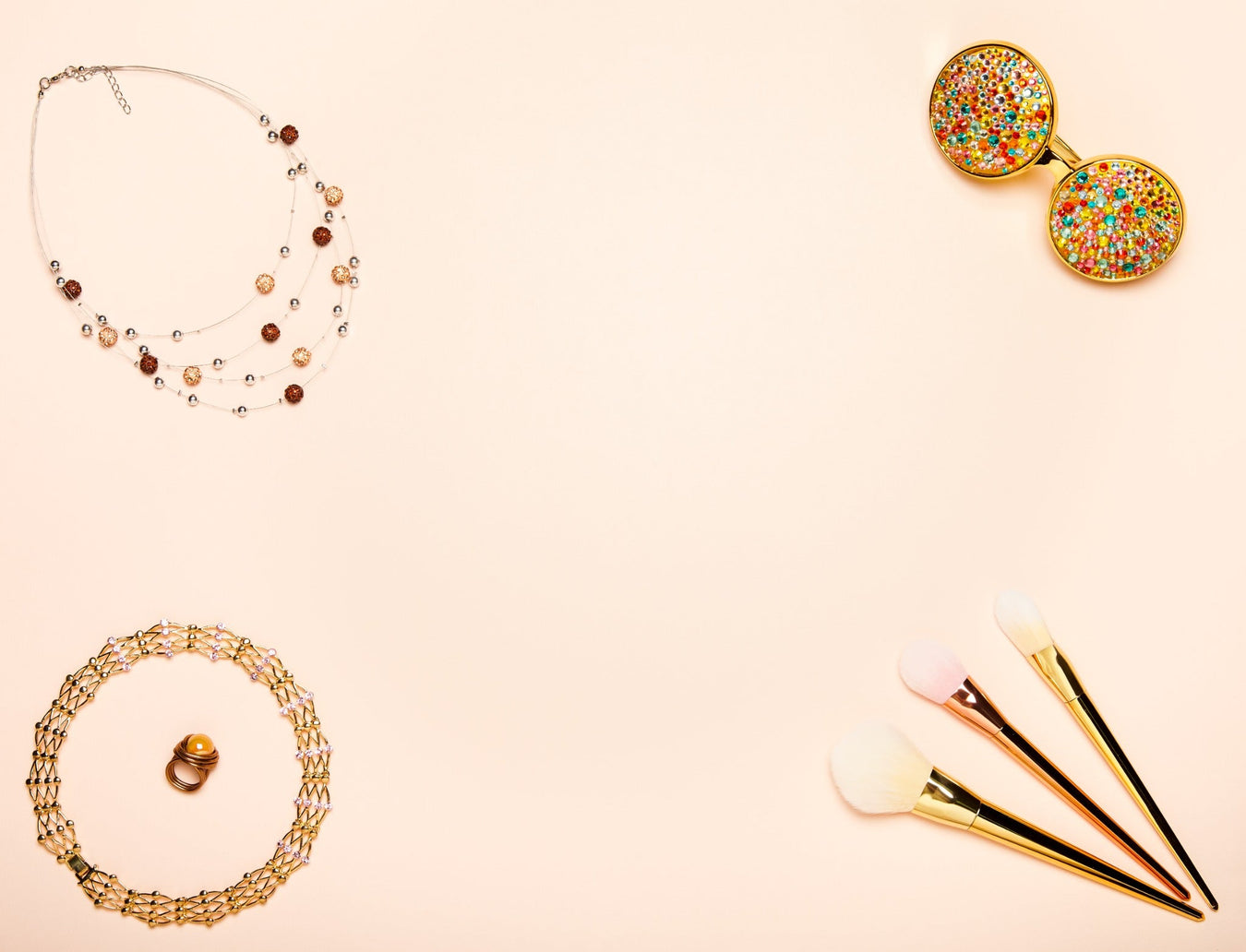 Flachliegendes Schmuck- und Accessoire-Set für Damen – Halskette, Ringe, Make-up-Pinsel und elegante Brille auf hellem Hintergrund