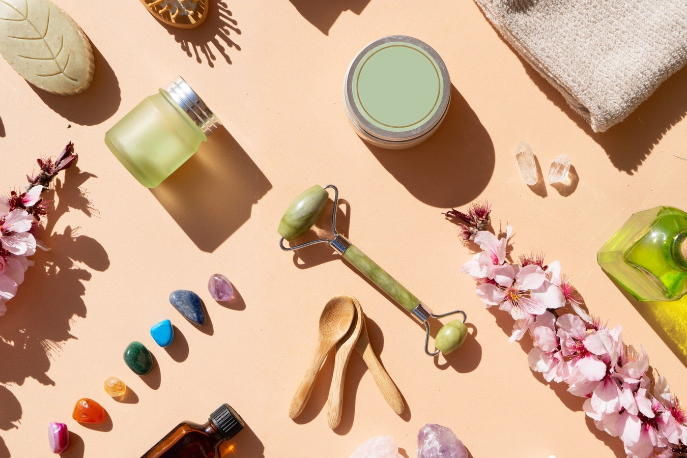 Wellness-Accessoires mit Massageroller, Aromaölen, Kristallen und Pflegeprodukten – eine stilvolle Szene für Entspannung und Selbstfürsorge.