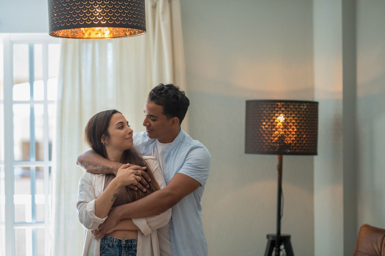 Innenbeleuchtung im Wohnzimmer – junges Paar in gemütlicher Atmosphäre mit stilvollen Lampen.