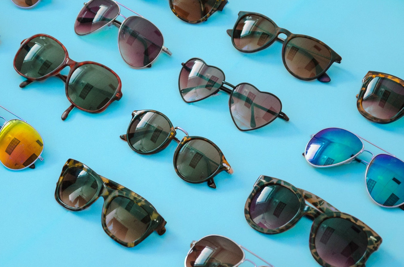 Verschiedene Sonnenbrillen in unterschiedlichen Designs auf blauem Hintergrund – modische und hochwertige Accessoires bei TECHTRAL.